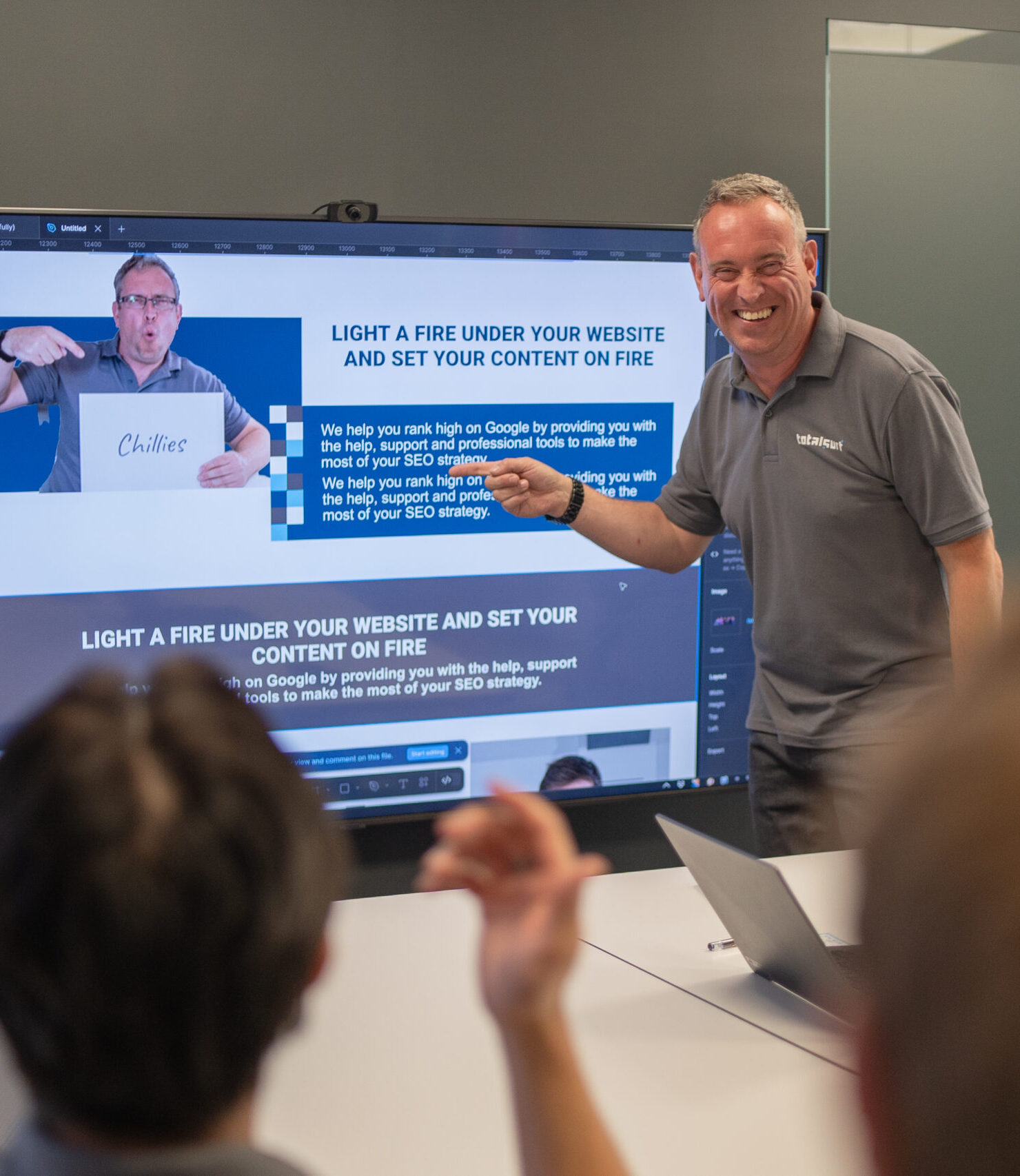 Man giving a presentation about SEO strategy, pointing to a screen displaying a related website.