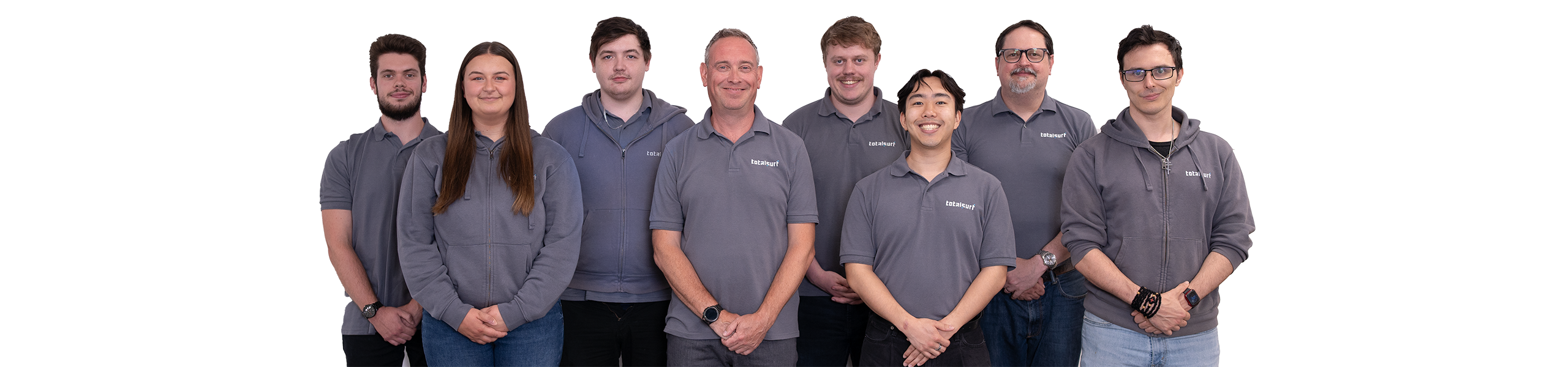 Eight people standing in a row, all wearing grey shirts, against a plain white background.