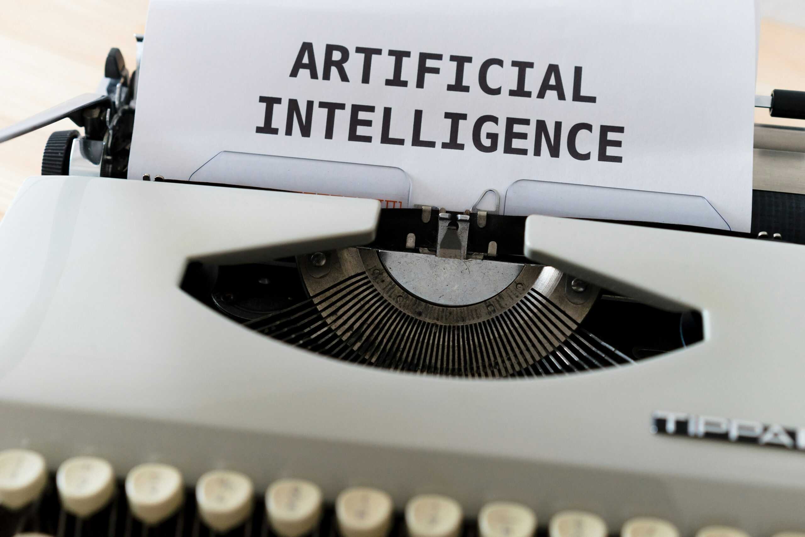 A typewriter with a sheet of paper displaying the words "ARTIFICIAL INTELLIGENCE" in bold.